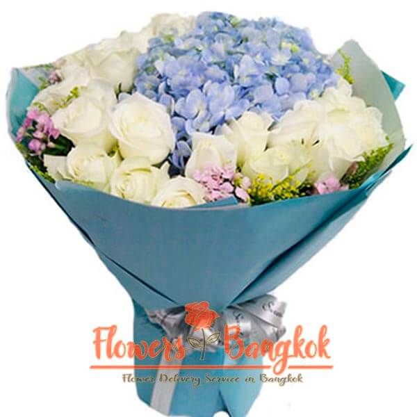 A large bouquet of gorgeous white roses and delicate hydrangeas.